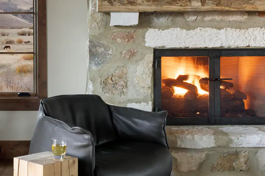 Rancho Feliz fireplace with horses in pasture outside window